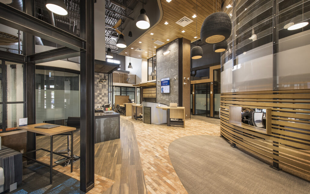 lobby with industrial details, metal beams, various shades of wood flooring
