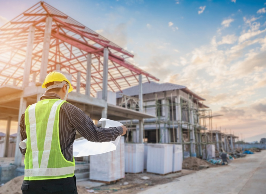 NewGround project manager looking at building plans at build site