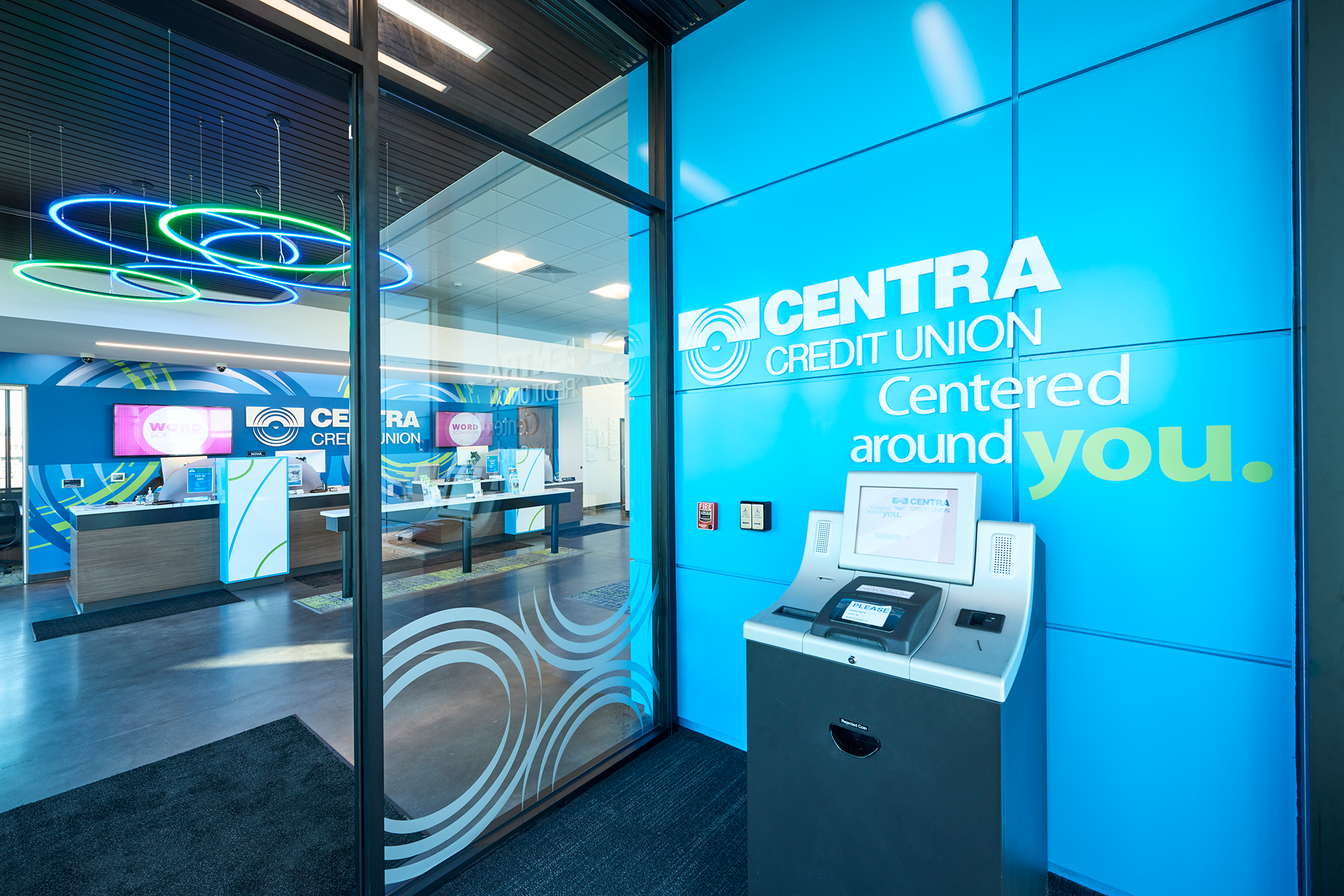 ATM vestibule of a building with a freestanding ATM and a blue branded wall that says Centra Credit Union Centered Around You