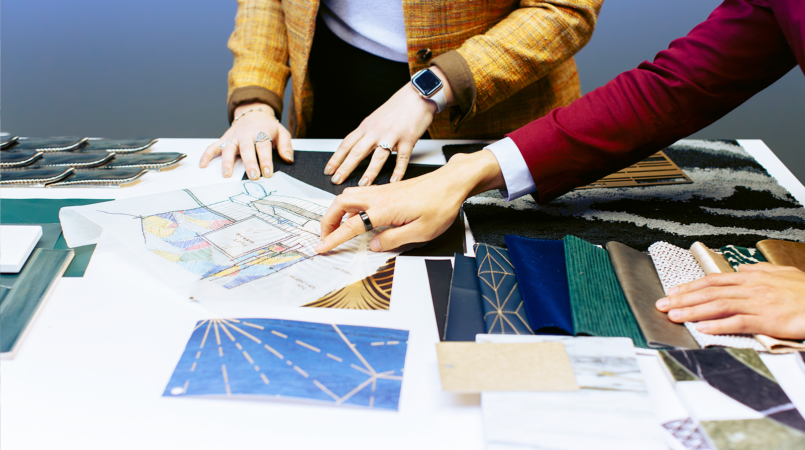 hands of 2 people discussing plans for Furniture and fixtures in a workplace