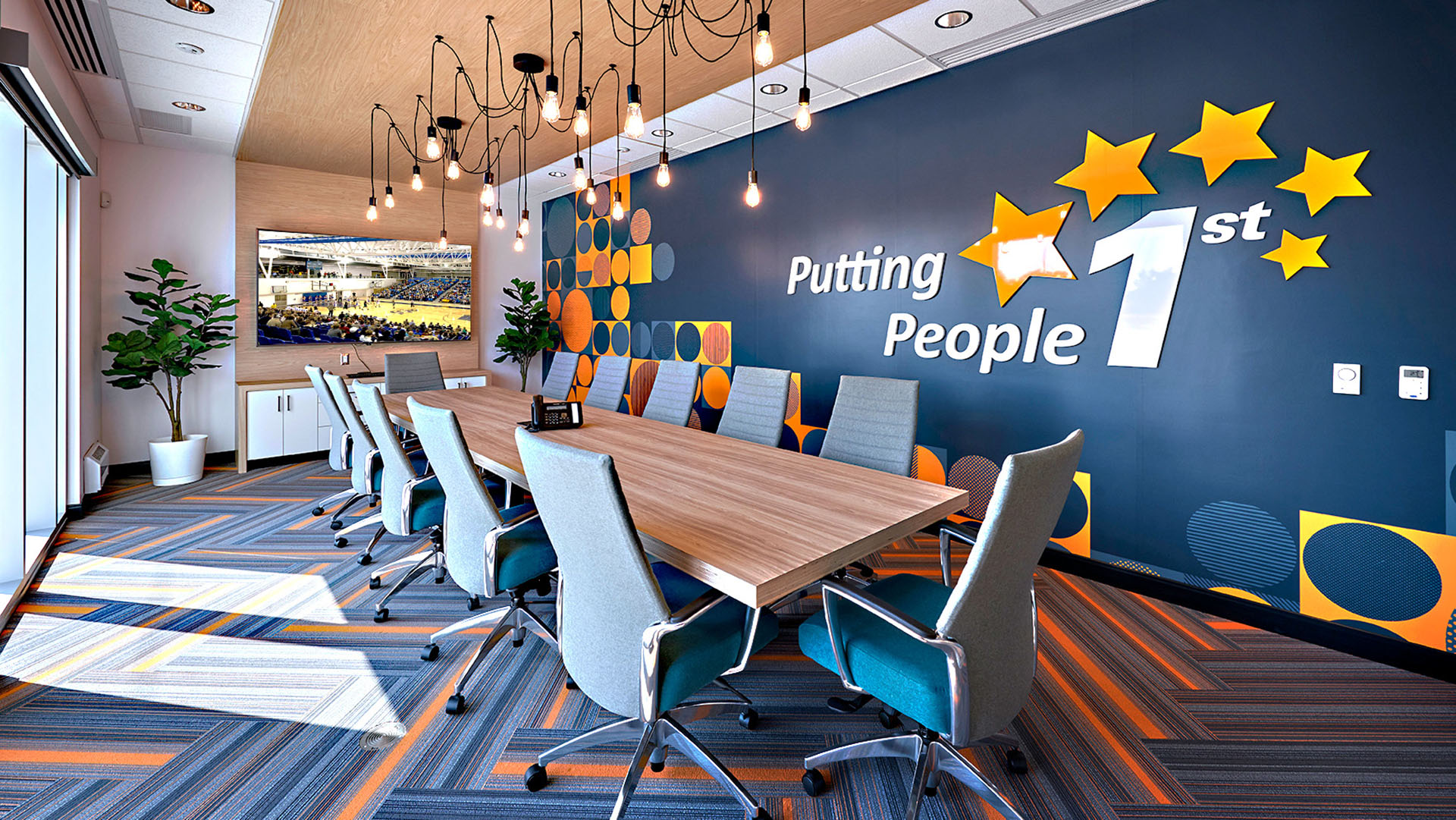 conference room with interior design by NewGround containing a long table and chairs, modern light fixtures and bright colors on the wall and floor